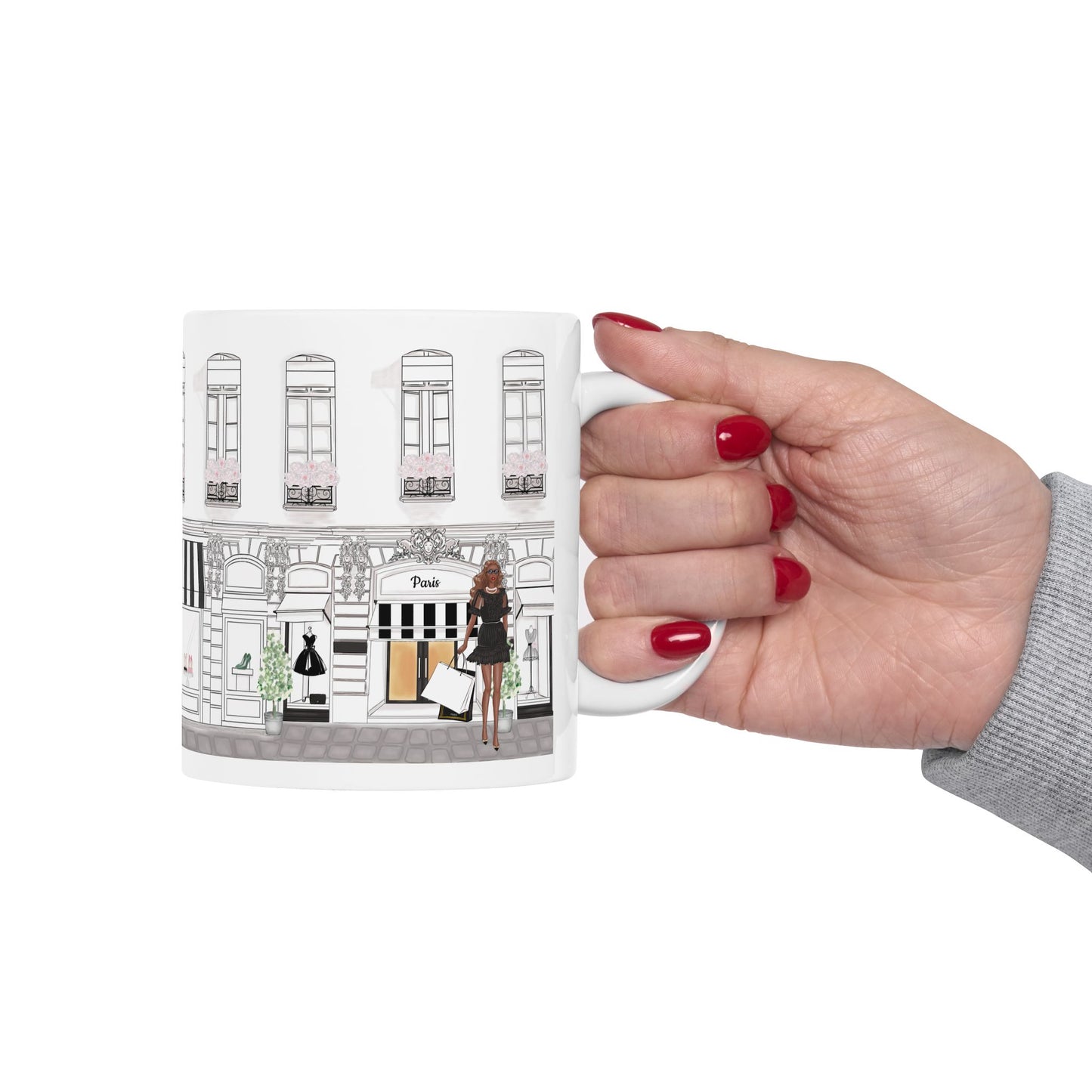 Hand holding a Haute in Paris Collection ceramic mug with customizable avatar, showing a fashionista outside a Paris boutique.