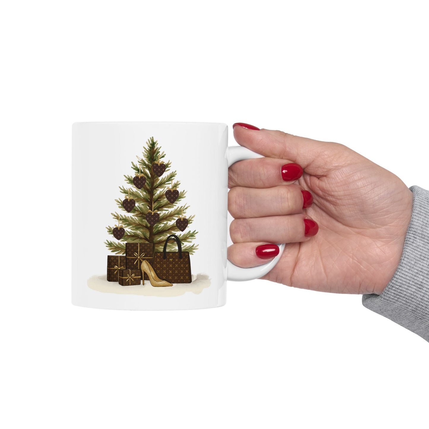 Hand holding a mug with a Christmas tree and gift bag design on a white background