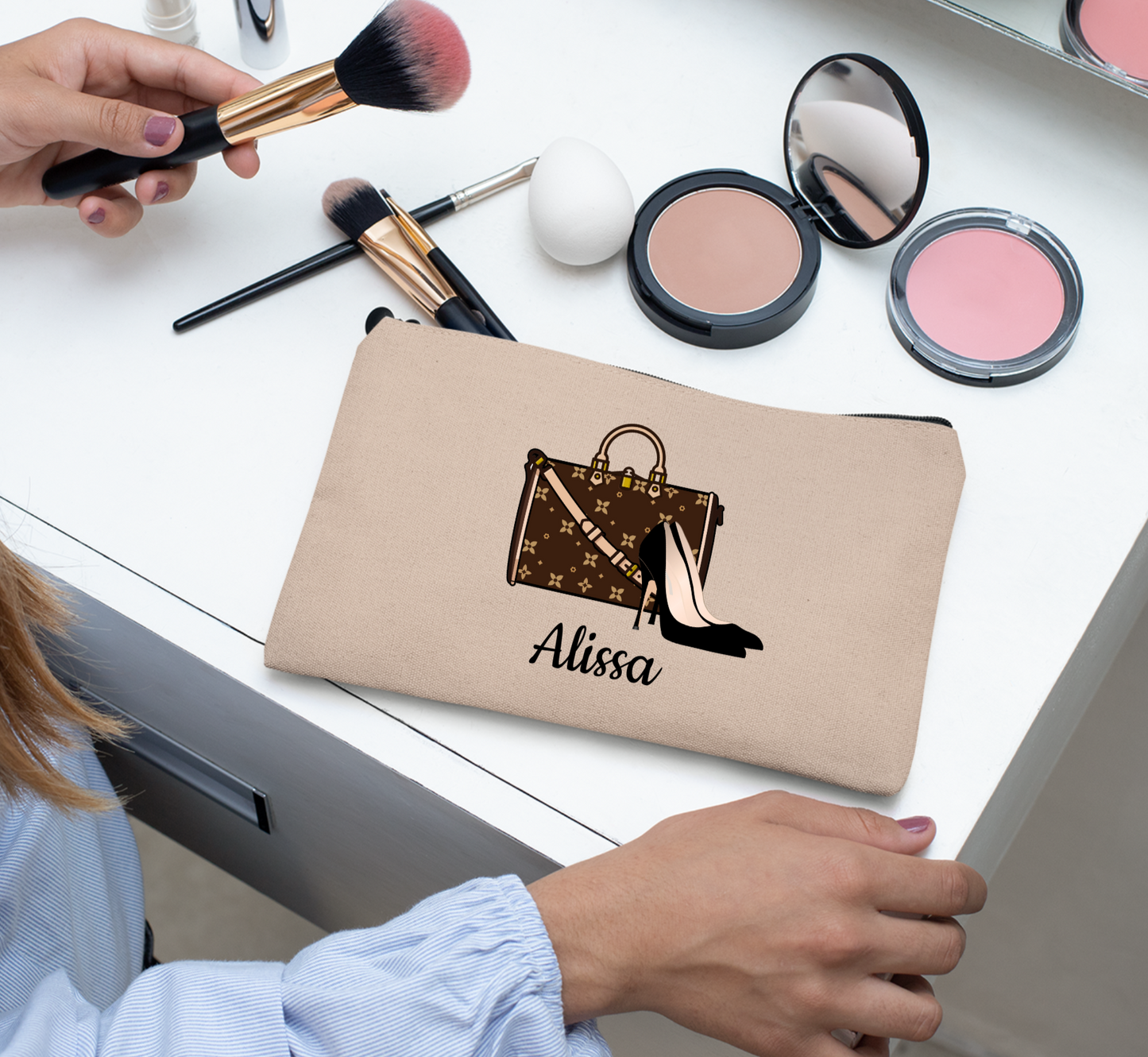 Taupe Makeup bag with 'Alissa' branding on a desk with makeup items