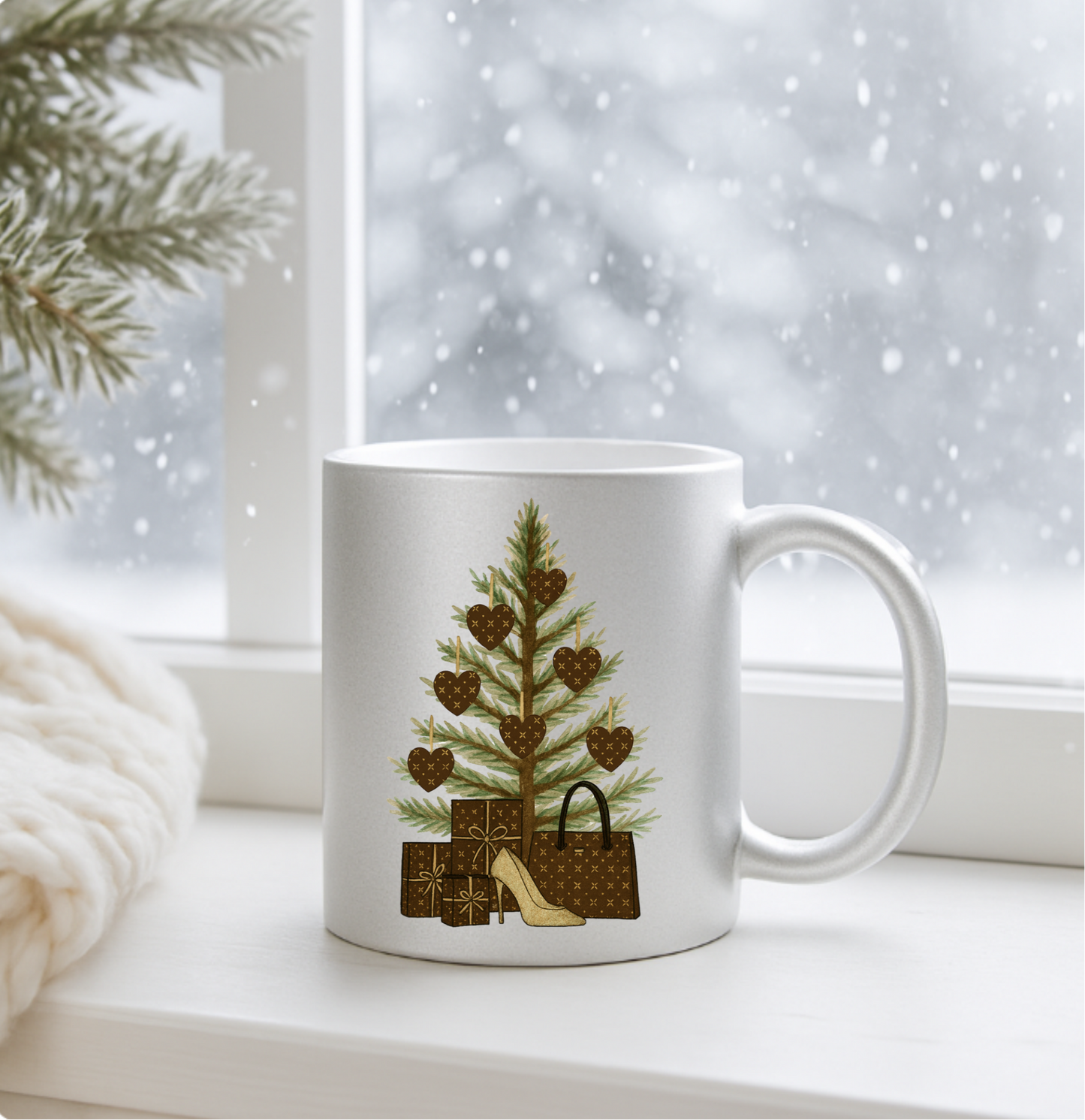Silver mug with a Christmas tree and gift design on a windowsill with snow outside.