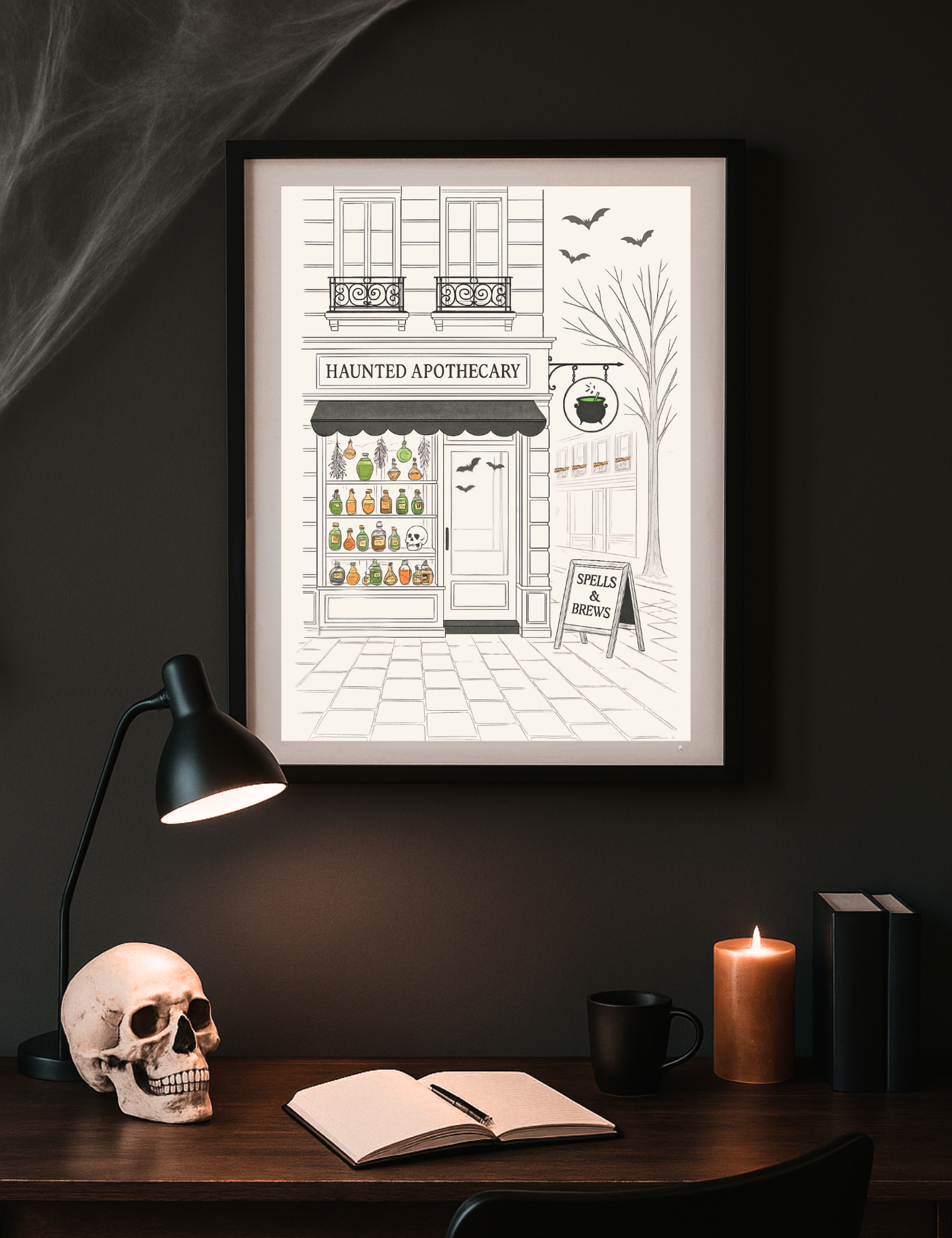 Framed illustration of a haunted apothecary on a dark wall above a desk with a skull, lamp, and books.