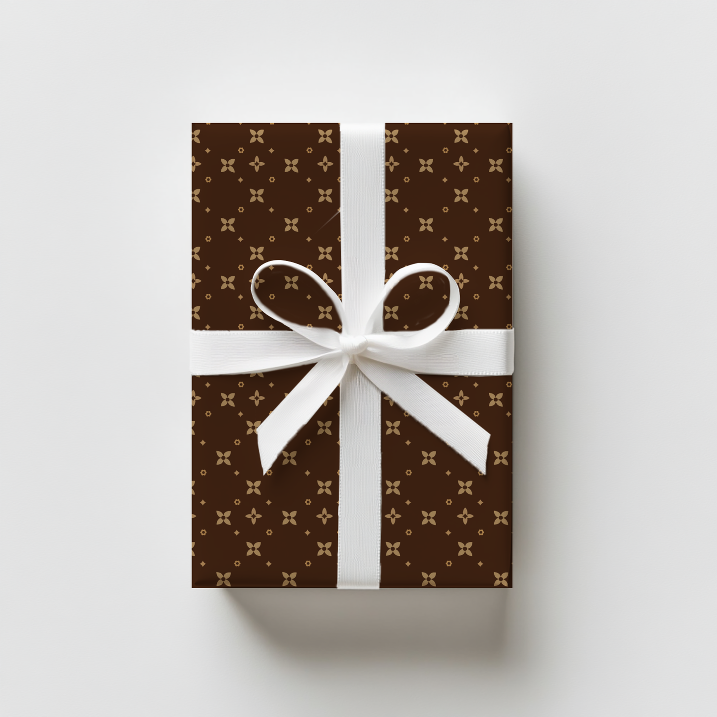 Gift box with brown and beige pattern and white ribbon on a light gray background
