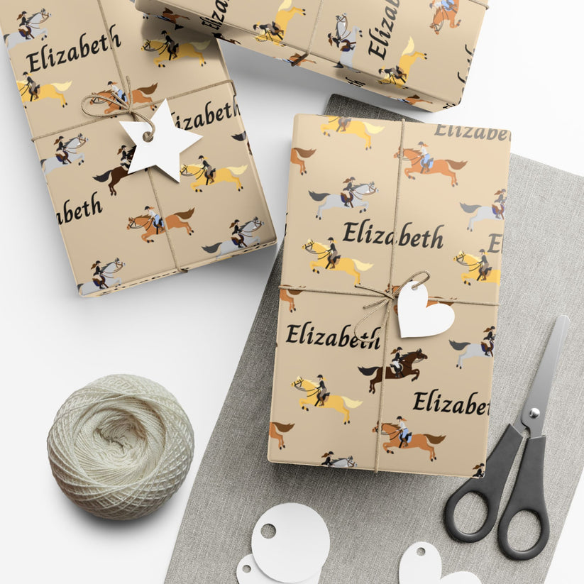Gift boxes wrapped in brown paper with horse pattern and 'Elizabeth' text, surrounded by yarn and scissors on a white surface.