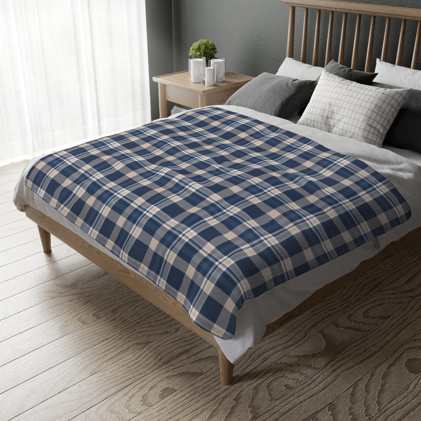 Bed with blue and beige checkered blanket in a bedroom setting