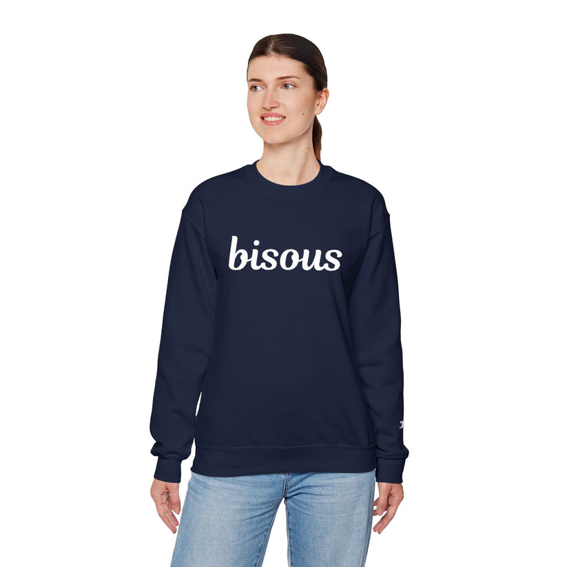Person wearing a navy blue sweatshirt with white embroidered 'bisous' text on a white background