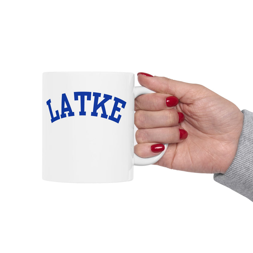 White mug with 'LATKE' printed in blue on a white background