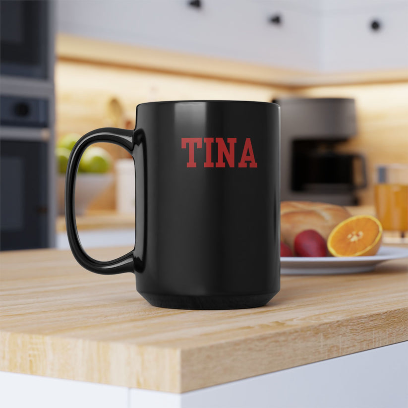 Black mug with 'TINA' in red on a kitchen counter