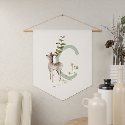 Decorative wall hanging with a deer and letter 'S' design on a white background, hanging on a neutral wall.