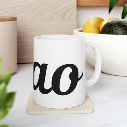 White mug with ' ciao' printed on it, placed on a wooden coaster with a blurred background of a kitchen setting.
