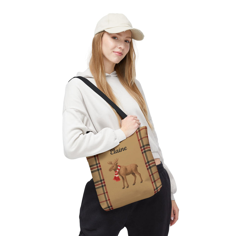 Person holding a plaid bag with a reindeer design and 'Elaine' text on a white background