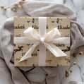 Gift box with horse pattern and white ribbon on a soft fabric background