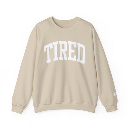 Beige sweatshirt with 'TIRED' text on a white background
