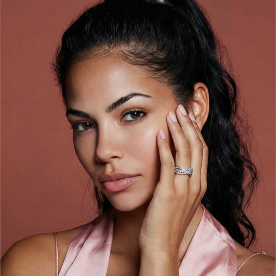 Woman with dark hair wearing a silver and moissanite infinity crossover ring