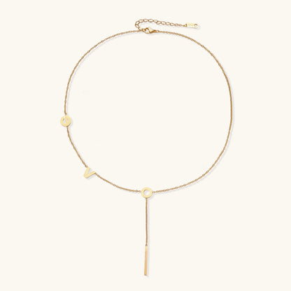 Gold necklace with letters spelling out "love"  on a white background