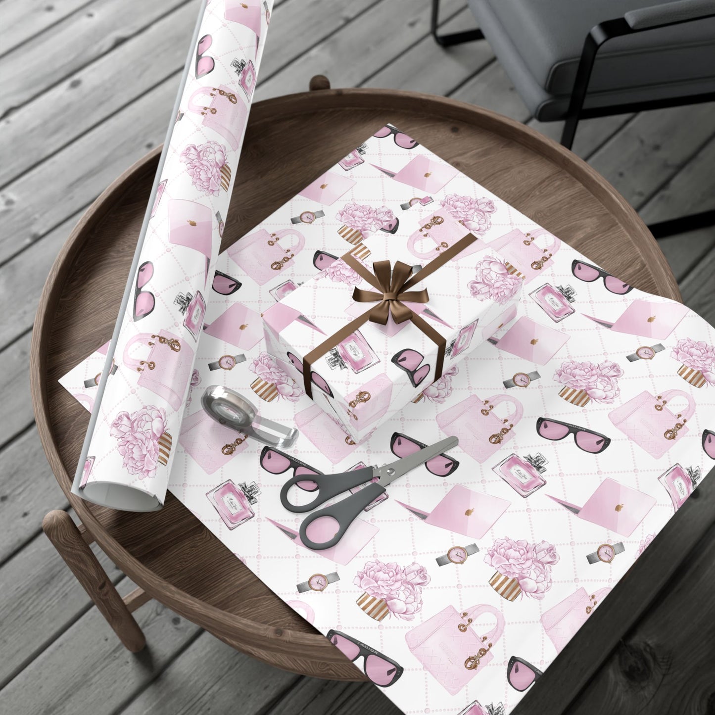 Pink and white fashion theme patterned gift wrap with scissors on a wooden table