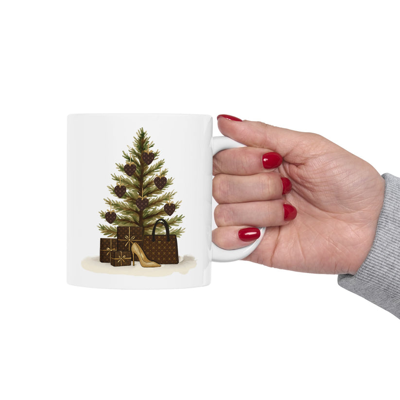Hand holding a mug with a Christmas tree and gift bag design on a white background