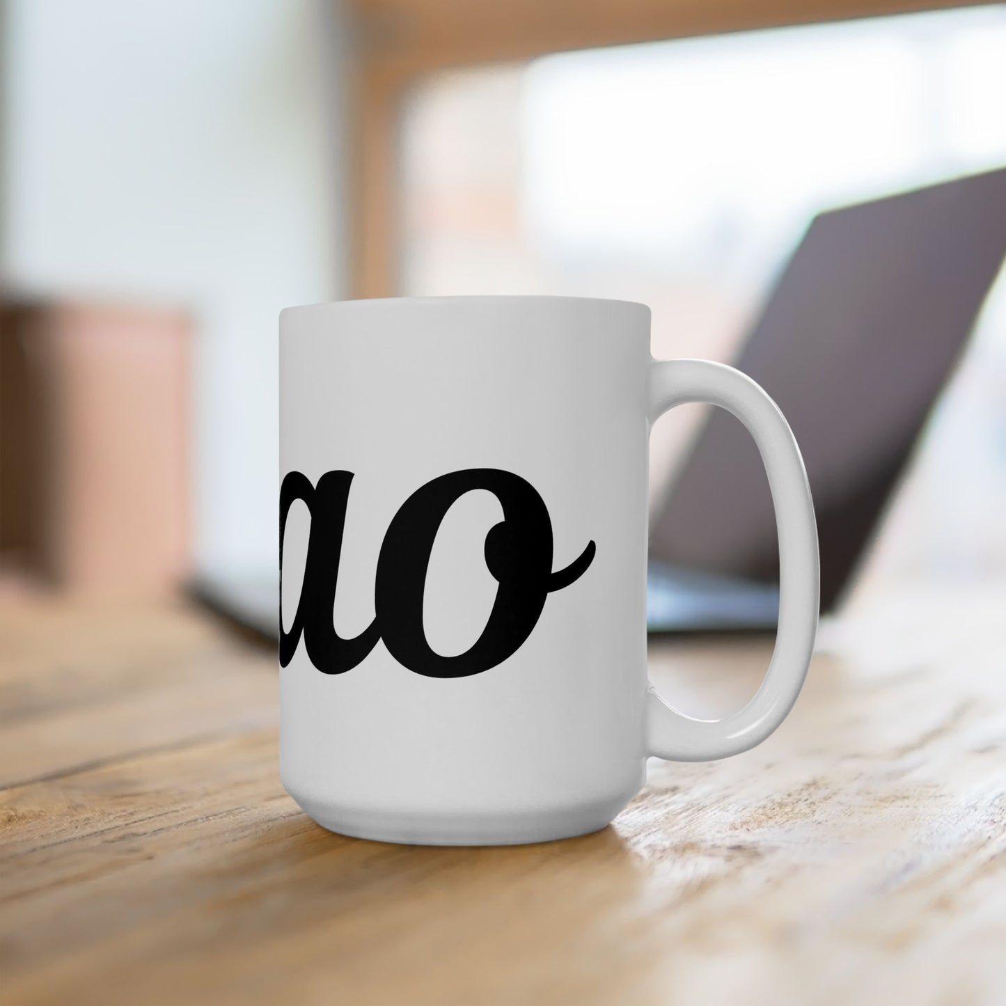 White mug with "ciao" black text on a wooden surface