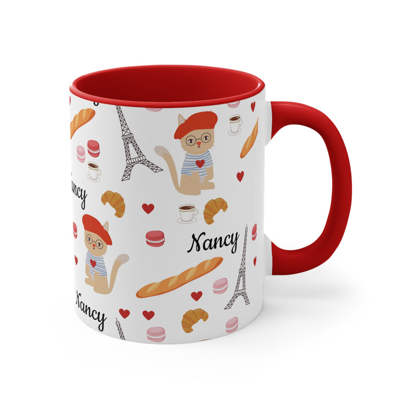 Mug with Paris-themed design featuring Eiffel Tower, croissants, and macarons on a white background.