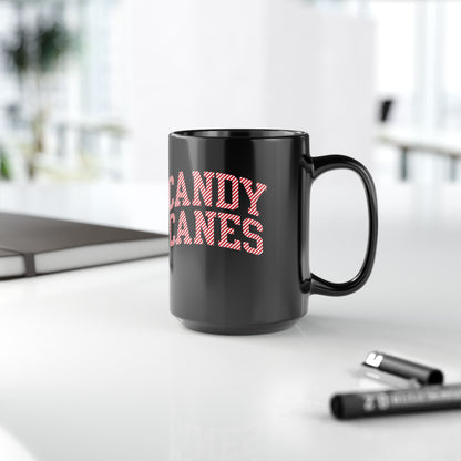 Black mug with 'CANDY CANES' text on a white surface with office items.