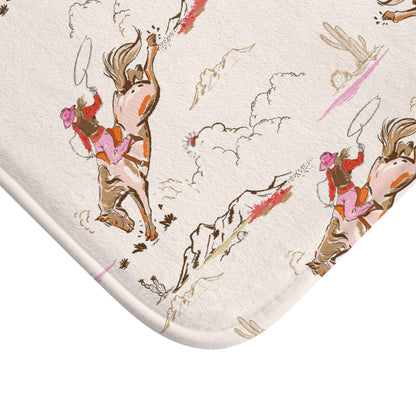 Patterned bath mat with a vintage cowgirl and bucking bronco print in pink tones.