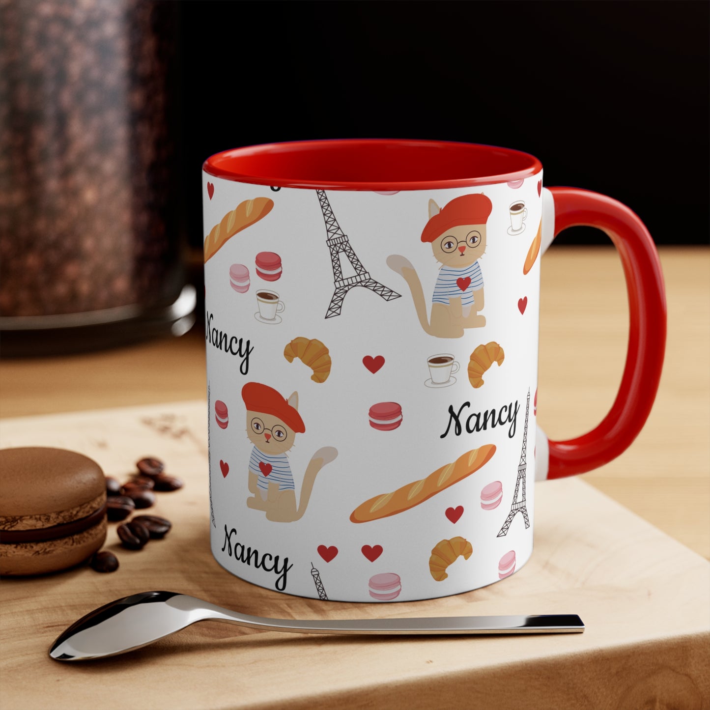 Mug with red handle featuring cat in a red beret surrounded by Parisian items  personalized name on a kitchen counter.