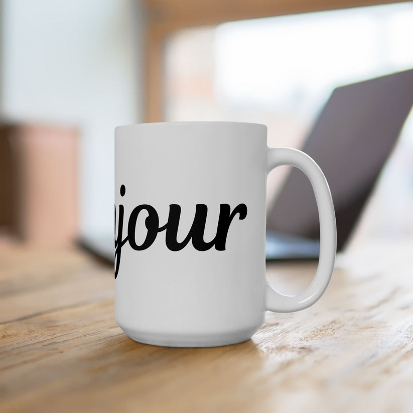 White mug with 'jour' printed on it, placed on a wooden surface.