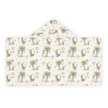 Patterned hooded towel with watercolor mice and bunnies and a monogrammed initial in a bathroom