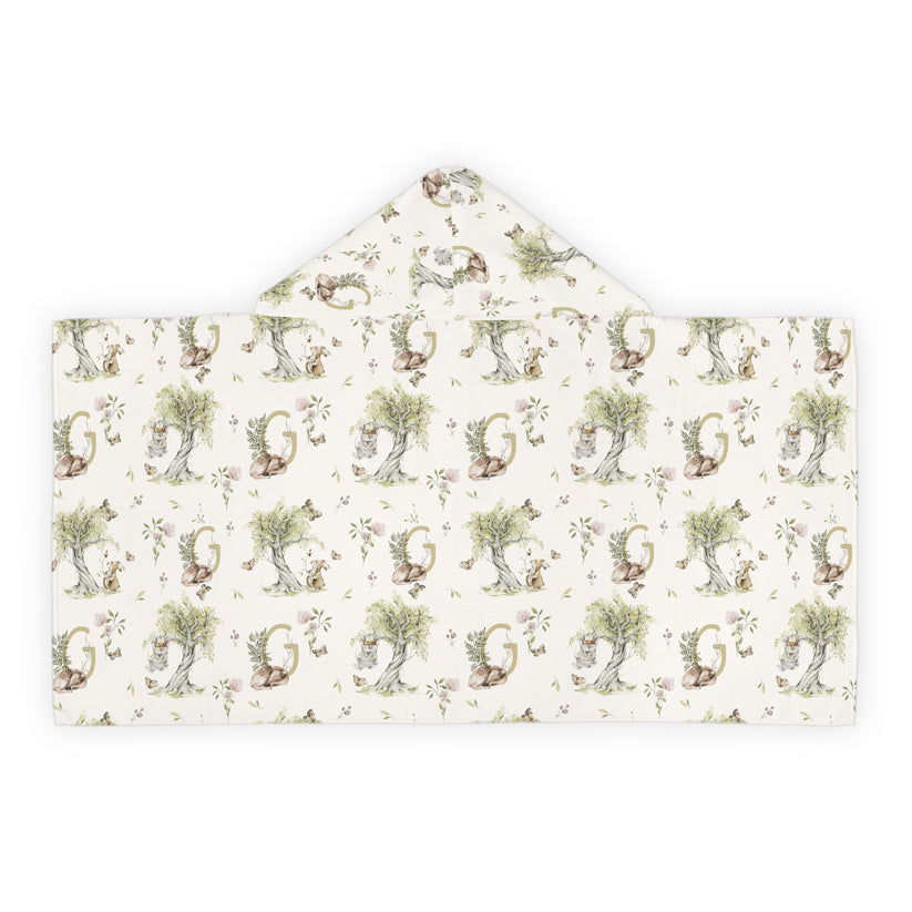 Patterned hooded towel with watercolor mice and bunnies and a monogrammed initial in a bathroom