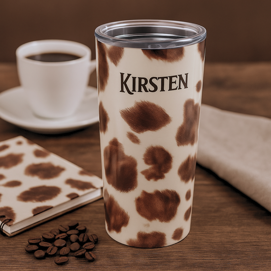 Appaloosa horse print tumbler with 'Kirsten' branding on a wooden surface with coffee and a notebook.