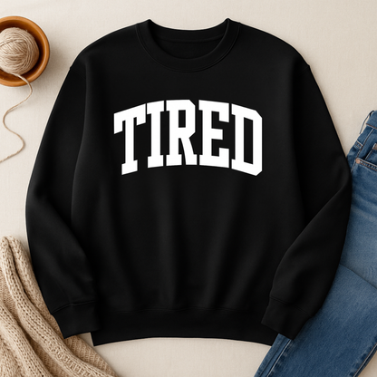 Black sweatshirt with 'TIRED' text on a neutral background