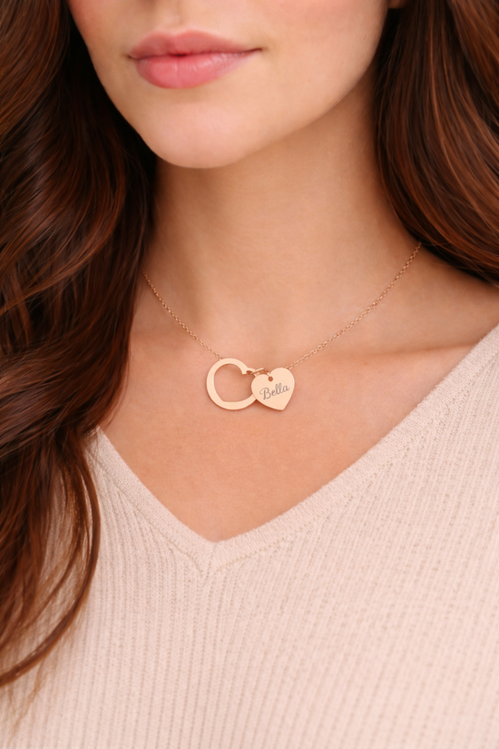 Rose gold necklace with heart-shaped pendant worn by a person