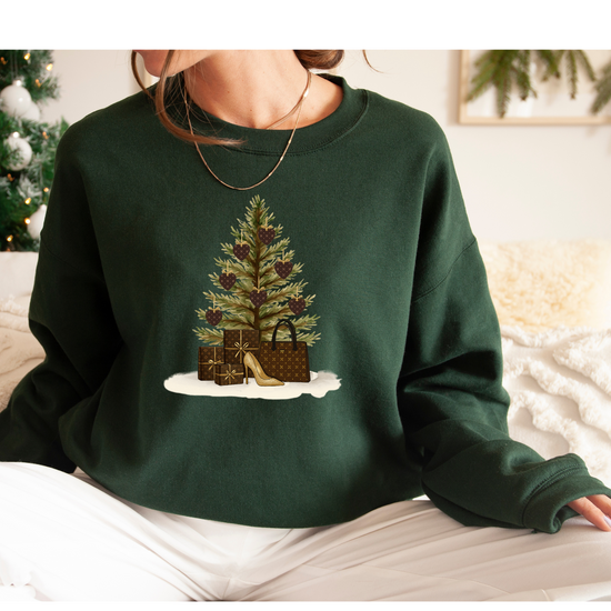 Green sweatshirt with Christmas tree and presents design worn by a person.
