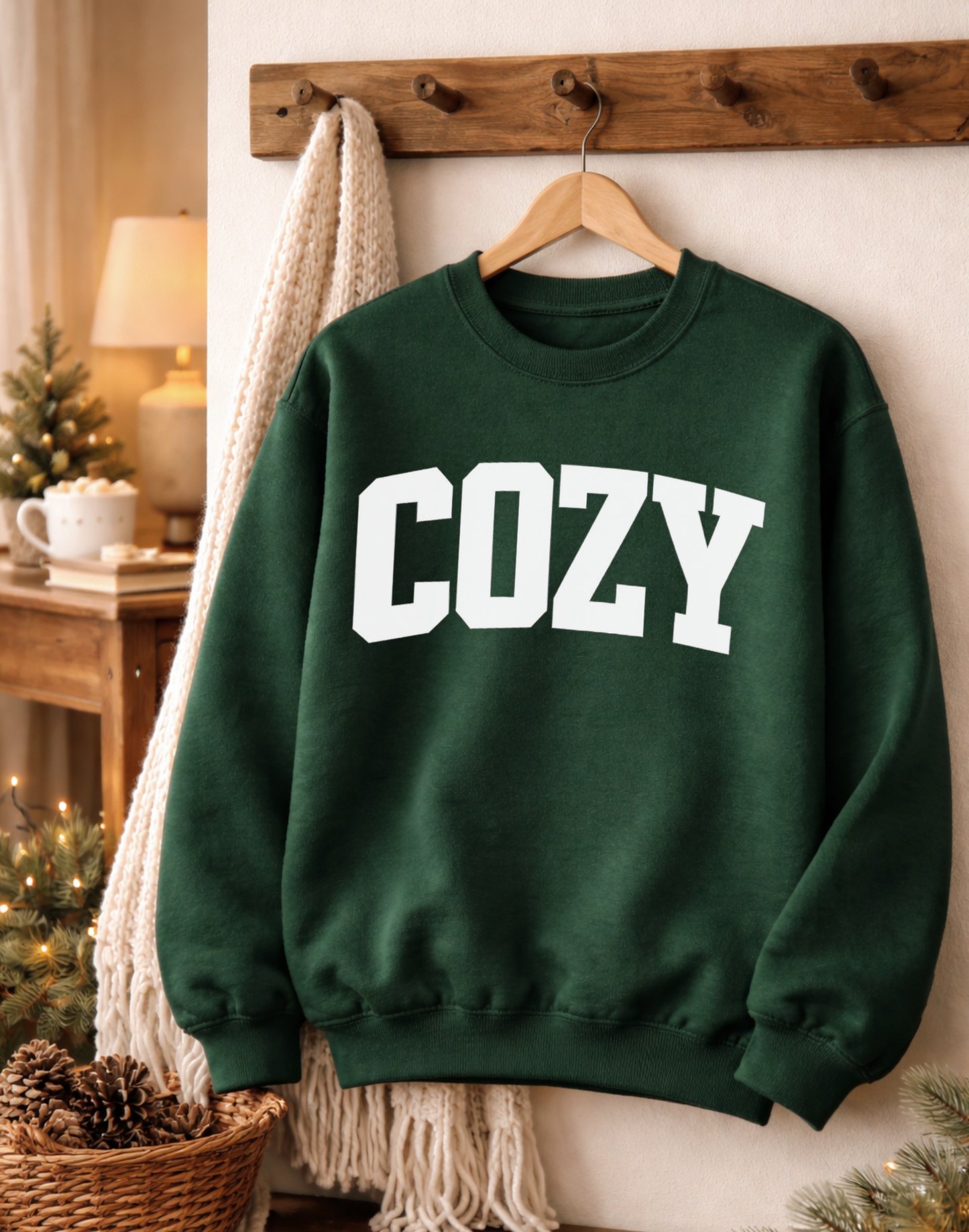 Green sweatshirt with 'COZY' text hanging on a wooden hanger against a neutral wall.