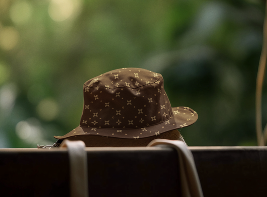 Brown patterned bucket hat on a blurred natural background