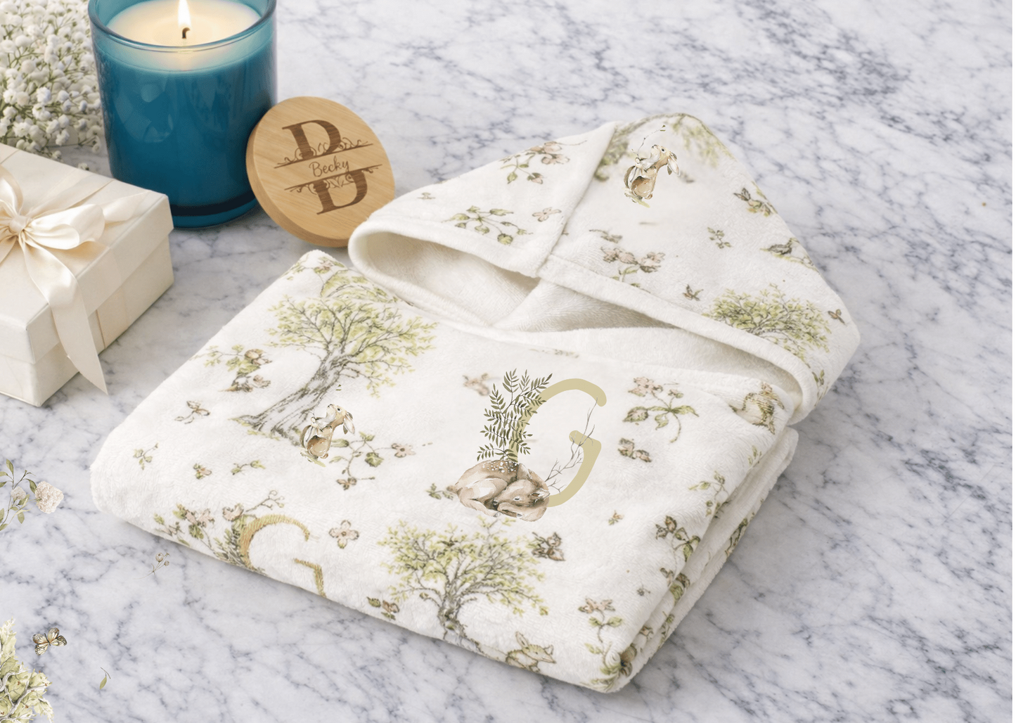 Hooded towel with watercolor mice and bunnies and a monogrammed initial in a bathroom