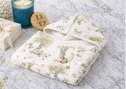 Hooded towel with watercolor mice and bunnies and a monogrammed initial in a bathroom