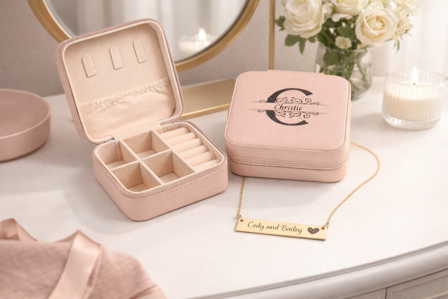 Pink jewelry box with a mirror, flowers, and a necklace on a table.