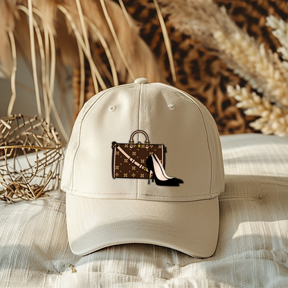 Beige cap with a handbag and high heel design on a textured surface with decorative elements.