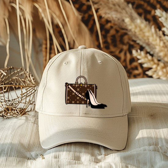 Beige cap with a handbag and high heel design on a textured surface with decorative elements.