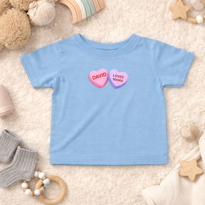 Blue children's t-shirt with heart-shaped text on a soft surface with toys around