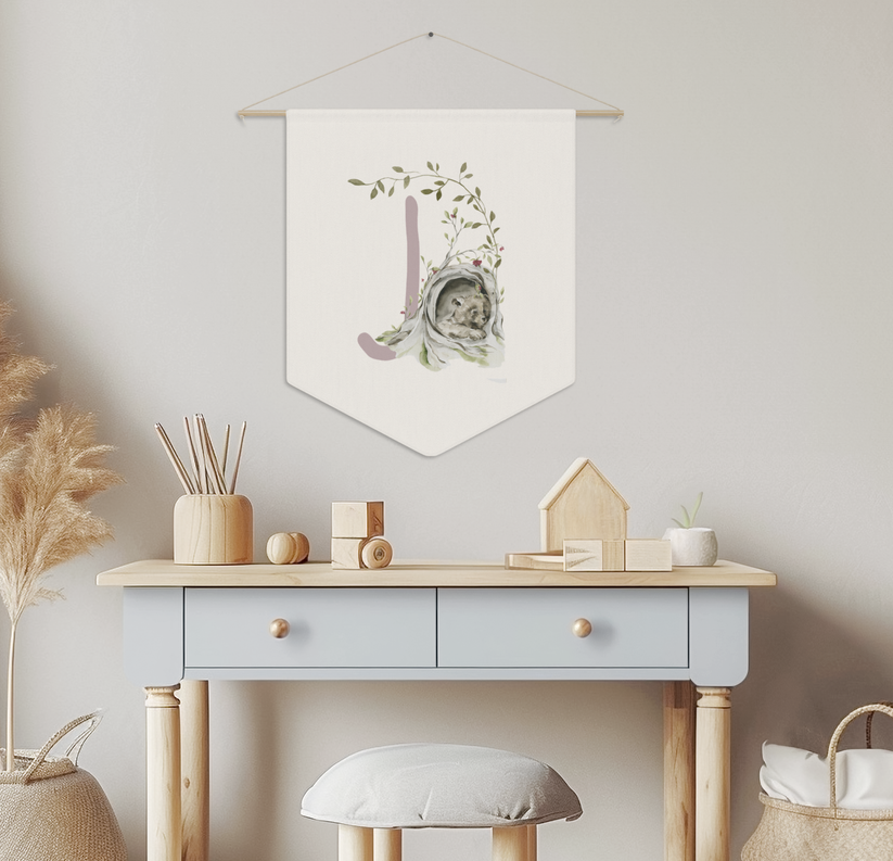 Nordic-style nursery with a monogrammed wall banner featuring a bear in an orchard, desk, stool, and decorative items.