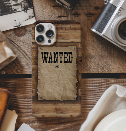 Phone case with 'WANTED' text on a wooden surface with vintage items