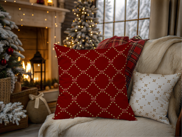 Decorative pillows on a couch with Christmas trees and lights in the background