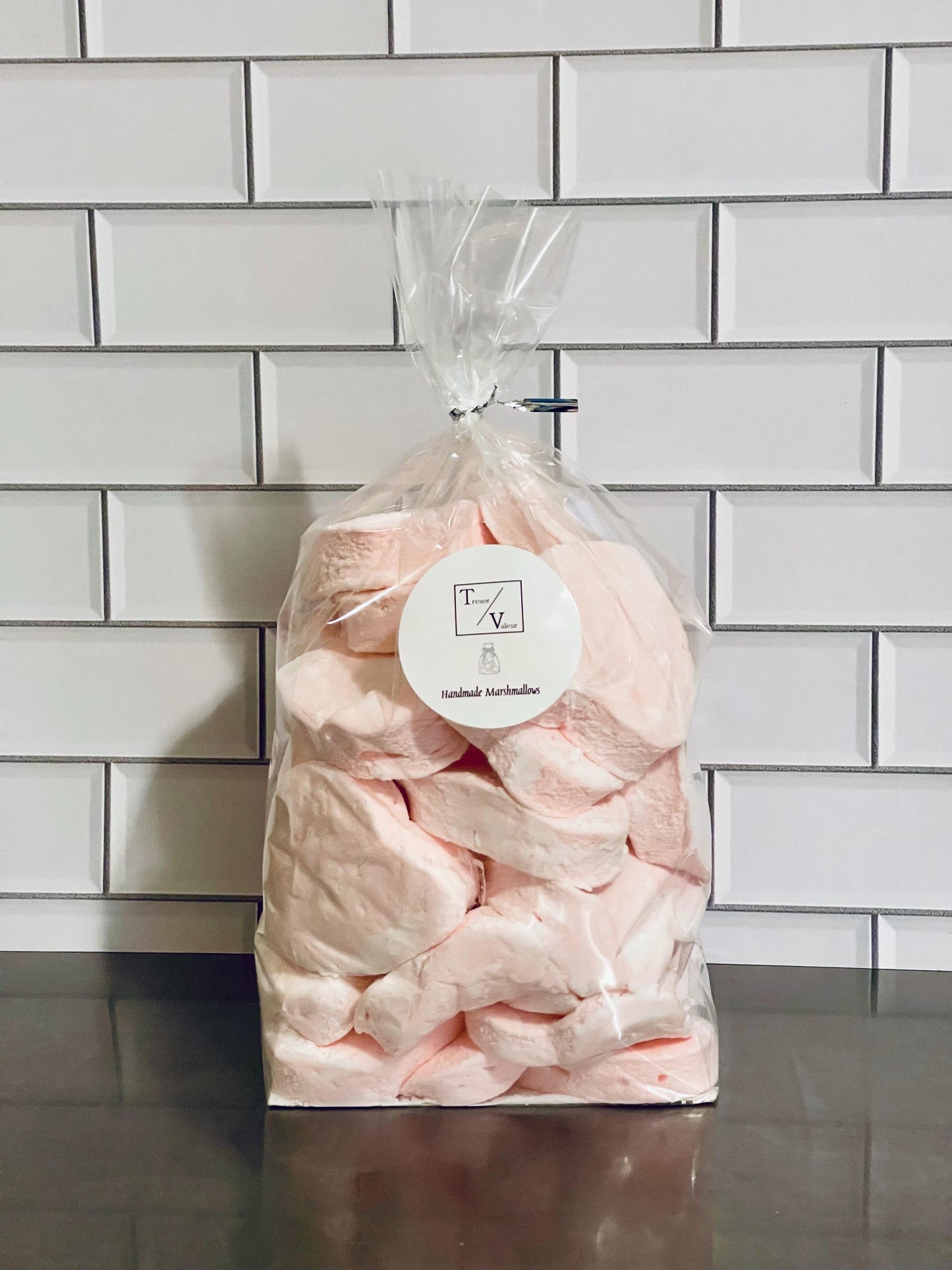 Bag of pink marshmallows with a visible brand label against a tiled wall.