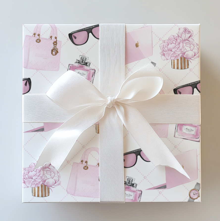 Gift box with pink fashion-themed design and white ribbon on a light gray background