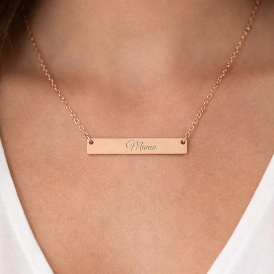 Rose gold necklace with 'Mama' engraving on a person wearing a white top.