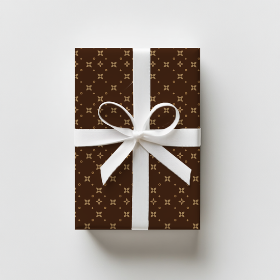 Gift box with brown and beige  pattern and white ribbon on a light gray background