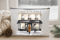 Pouch with a design of a woman in a yellow coat walking past a building on a snowy street.
