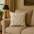 Decorative pillow with gold key pattern on a beige sofa in a living room setting.