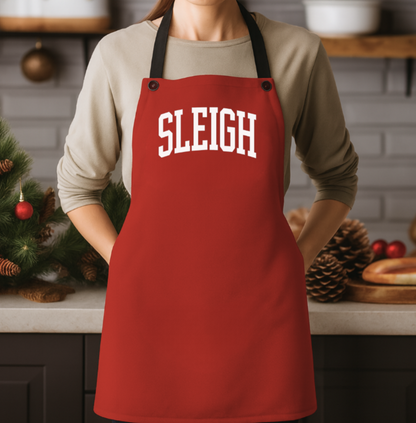 Person wearing a red apron with 'SLEIGH' text in a kitchen setting